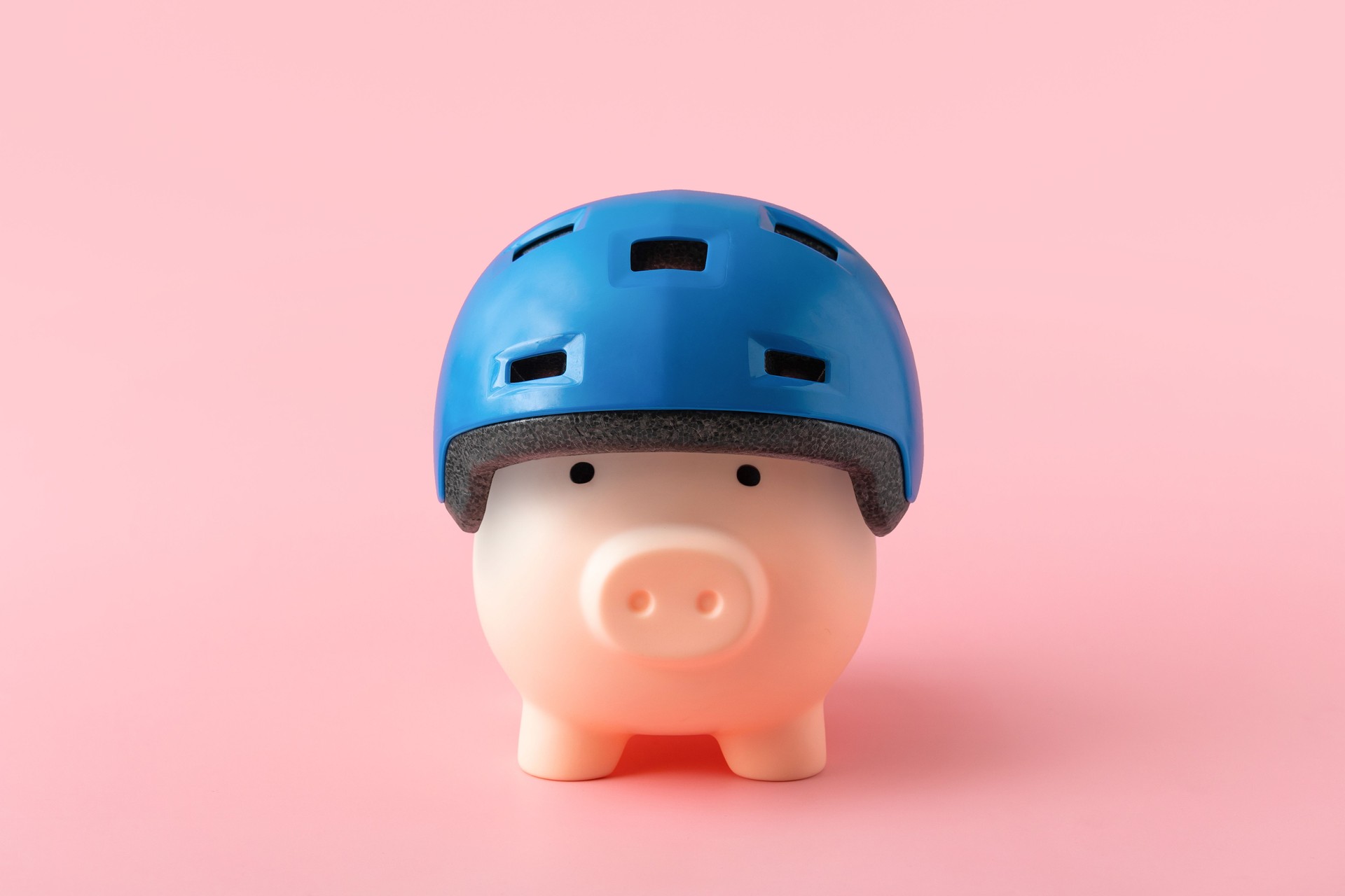 Tirelire en casque bleu sur fond rose. Protection financière et concept d’assurance
